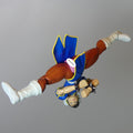 Street Fighter Chun-Li action figure posed upside down against a solid gray background.