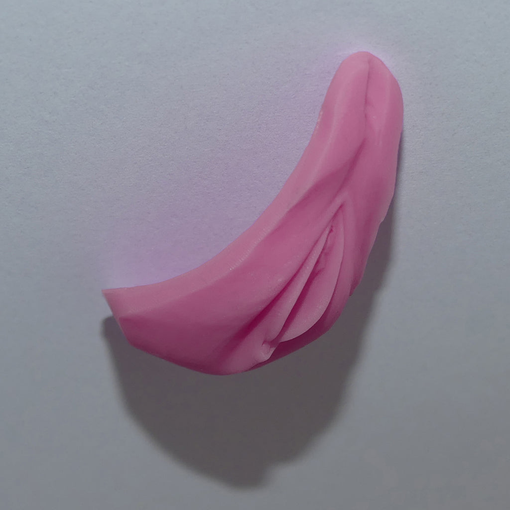Pink silicone female genitals shown from the side against a plain light gray background.