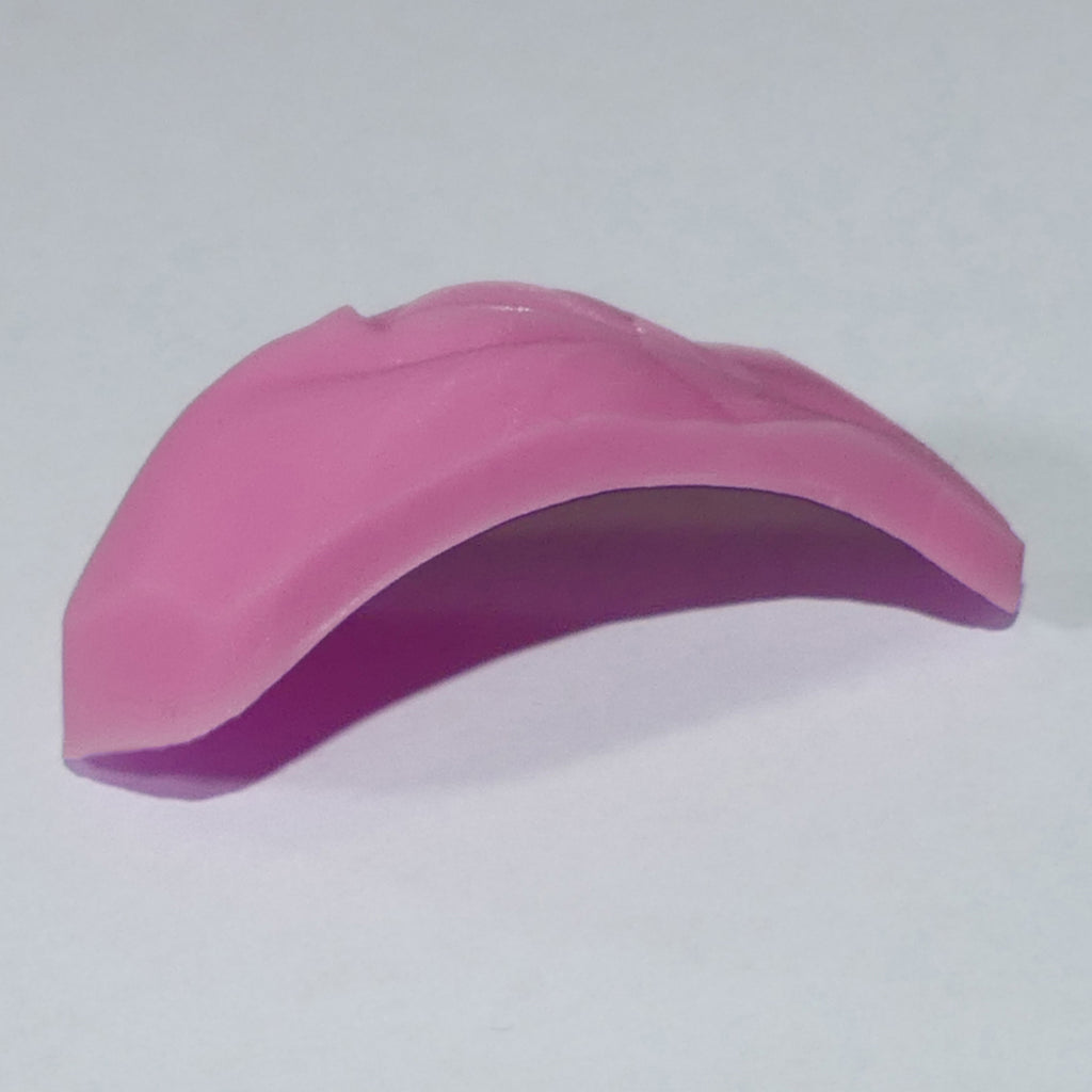 A pink curved silicone, vagina, vulva, female genitalia, accessory for 1/6 scale dolls.  Shown on a plain light gray background.
