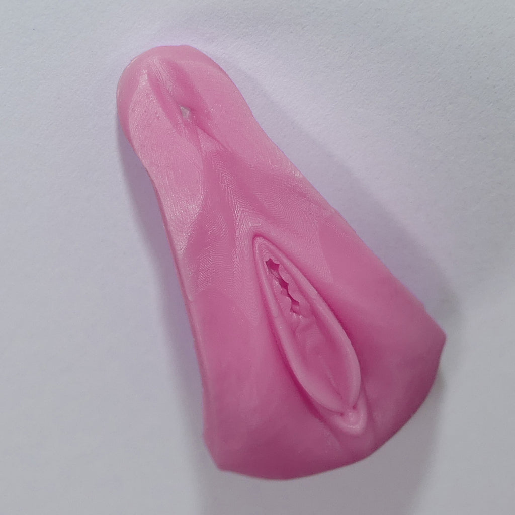 A pink silicone adult novelty vagina product with a realistic textured surface, photographed on a plain light background.